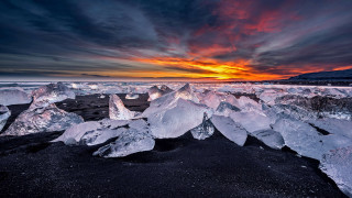 Sunset ice chunks mountain beach - a dark sky free wallpaper