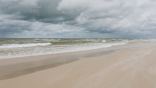 Sandy beach waves cloudy sky - a sandy beach free wallpaper