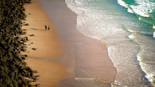 Beach walking people ocean waves - a rocky cliff free wallpaper