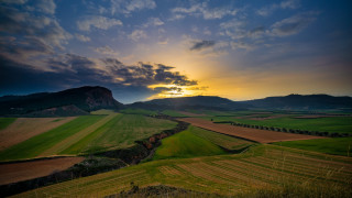 Sunset green field mountains cloudy - free landscape wallpaper