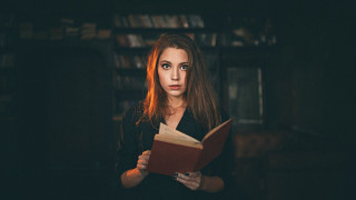 Woman holding book serious portrait - a book in her hands free wallpaper