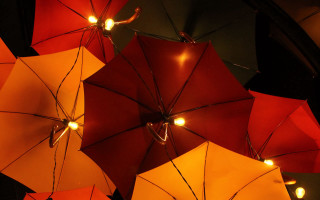 Red yellow umbrellas kinetic art - a black wall free wallpaper