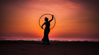 Woman hoop beach sunset cinematic - the sun setting behind her free wallpaper