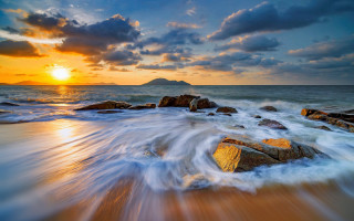 Sunset ocean waves rocks mountain 2 - a sunset over the ocean free wallpaper