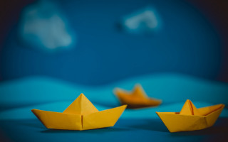 Yellow paper boat blue surface - a blue surface free wallpaper for desktop