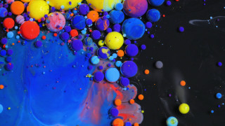 Colorful balls floating black liquid - a black surface free wallpaper for desktop