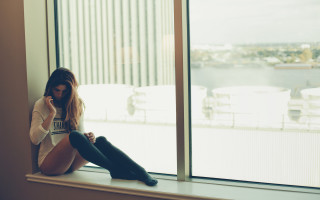 Woman sitting window city tilt - a window sill free wallpaper