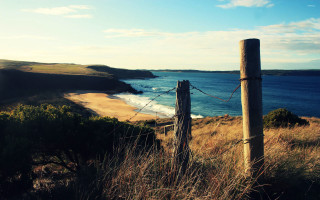 Wooden post grassy hill ocean - a wooden post free wallpaper
