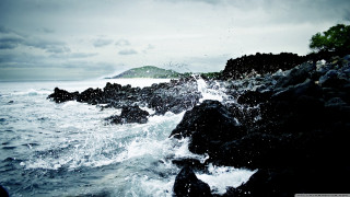 Rocky shore water splashing island - a small island in the distance free wallpaper