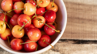 Bowl cherries wooden table spoon - a wooden table top free wallpaper