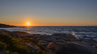 Sunset ocean rocky shore lighthouse - a sunset over the ocean free wallpaper