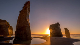 Sunset ocean rocks beach reflection - a beach in the foreground free wallpaper