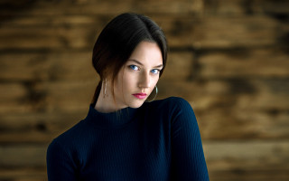 Blue eyed woman black top - a wooden wall free wallpaper
