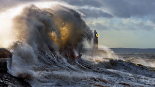 Lighthouse wave ocean cloudy day 3 - a lighthouse in the background free wallpaper