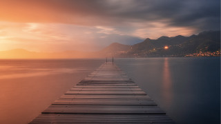 Long dock sunset mountains lighthouse - a light house in the distance free wallpaper for desktop