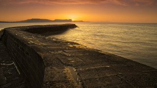 Sunset ocean stone wall island - a small island in the distance free wallpaper