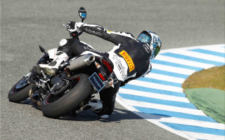 Man riding motorcycle race track - his hand free wallpaper