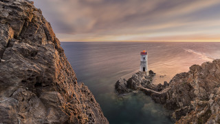 Lighthouse rocky cliff ocean sunset 3 - a rocky cliff free wallpaper