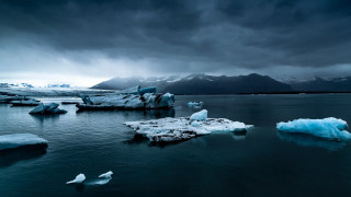Icebergs water mountains sky bird - the water under a cloudy sky free wallpaper
