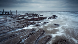 Night beach water rocks pier - a pier in the distance free wallpaper