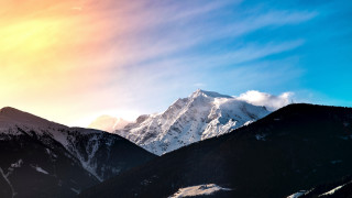 Mountain range snowy background sun - a bright sun in the sky above free wallpaper