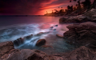 Sunset rocky beach palm trees - a red sky free wallpaper