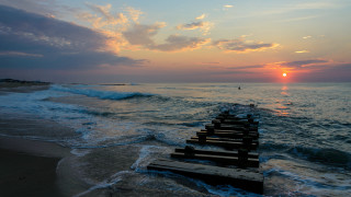 Sunset ocean benches person distant - a sunset over the ocean free wallpaper