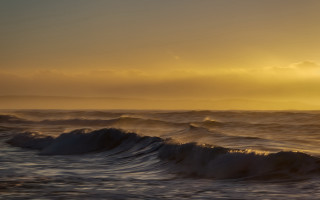 Sunset ocean waves lighthouse yellow - a lighthouse in the distance free wallpaper