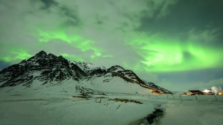 Green white aurora mountain scene - a house in the foreground free wallpaper