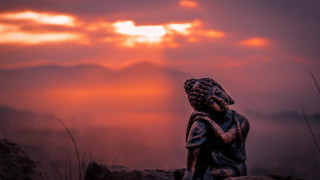 Statue sitting rock sunset clouds - a statue of a person free wallpaper