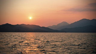 Sunset mountains water boat paddle - a sunset over a body of water free wallpaper