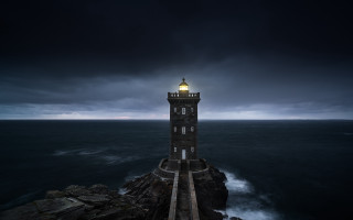 Lighthouse rocky cliff dark sky - a rocky cliff free wallpaper