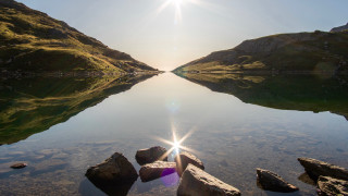 Lake rocks purple umbrella mountains - a mountain range in the background free wallpaper