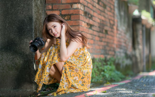 Woman yellow dress camera brick - a graffiti free wallpaper