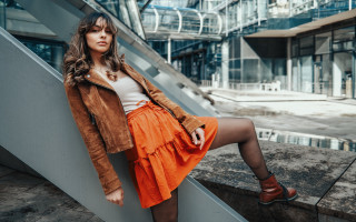 Woman orange skirt jacket railway - outside a building free wallpaper