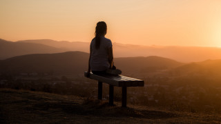Woman sitting bench sunset valley - a city in the distance free wallpaper