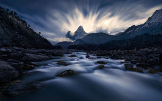 River forest mountains night cloudy - a lush green forest under a cloudy sky free wallpaper