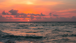 Sunset ocean boat clouds beach 2 - a surfboard in the foreground free wallpaper
