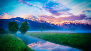 Lush green river mountains cloudy - a lush green field under a cloudy sky free wallpaper