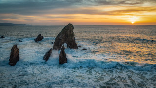 Sunset ocean waves rocks beach - a large rock free wallpaper