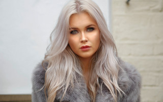 Christabel grey fur coat brick - a brick wall behind her free wallpaper