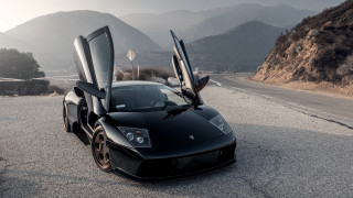 Black sports car mountains cloudy - a black sports car free wallpaper