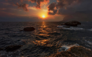 Sunset ocean rocky shore cityscape - a large body of water free wallpaper