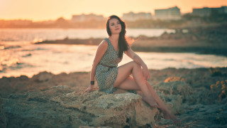 Woman sitting rock ocean sunset - a rock near the ocean free wallpaper