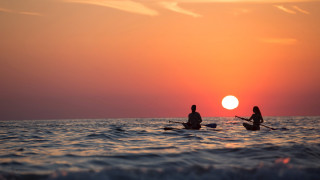 Sunset boat paddle ocean horizon - the sun setting behind them free wallpaper for desktop