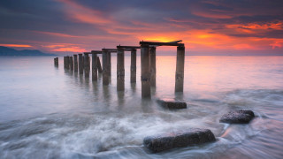 Wooden posts ocean sunset red - a few wave free wallpaper