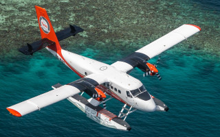 Small plane over water with - the background and a boat free wallpaper