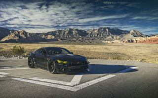 Black sports car mountains clouds - a parking lot in front free wallpaper