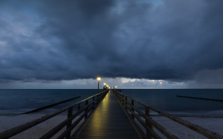 Pier light night water clouds - a dark sky above free wallpaper