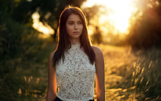 Woman field sunset blurry flare - the sun setting behind her free wallpaper
